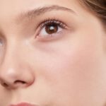 Close-up portrait capturing the natural beauty and smooth skin of a young woman.